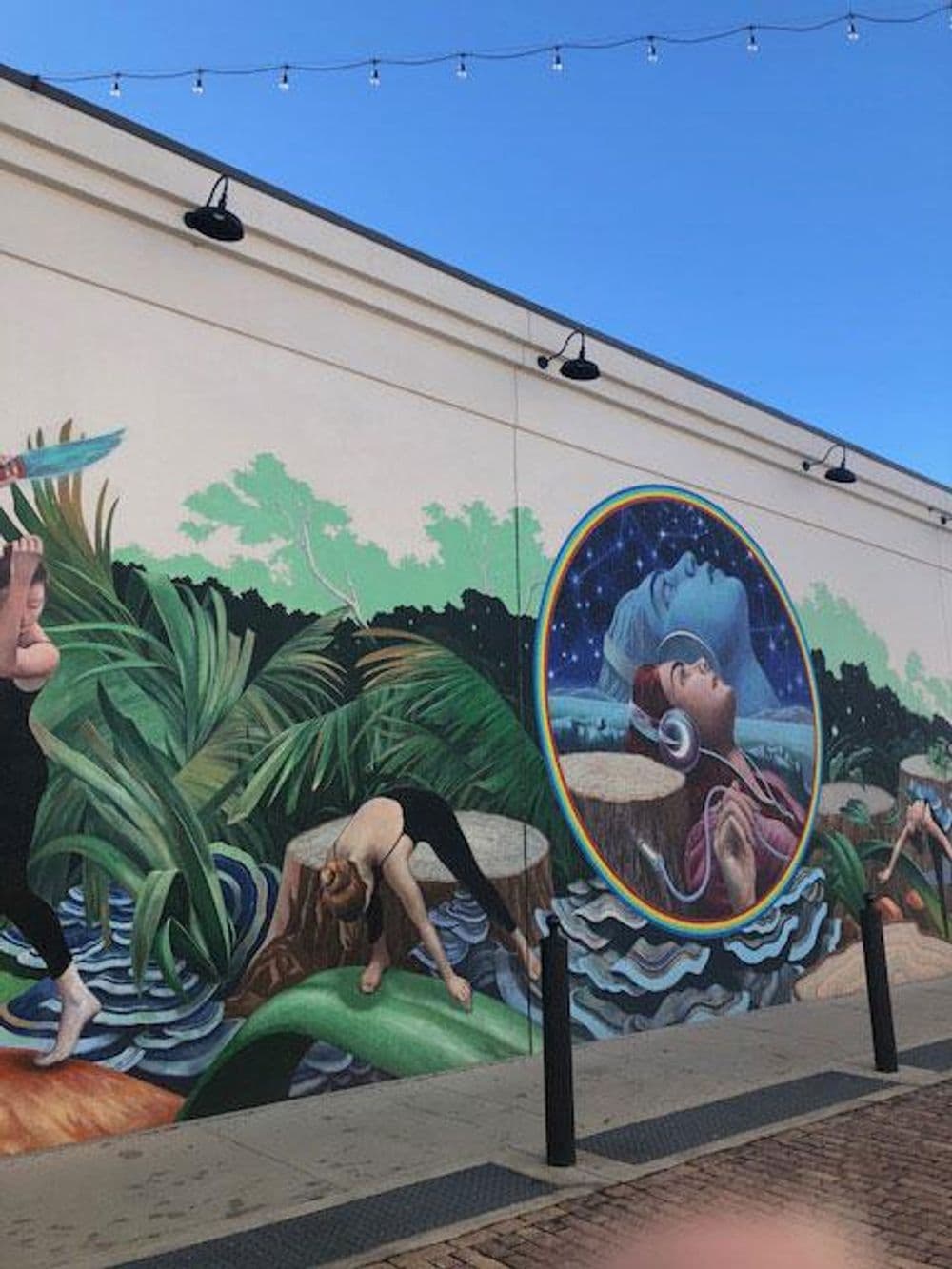 Colorful mural depicting figures in yoga poses and a meditative scene surrounded by nature.